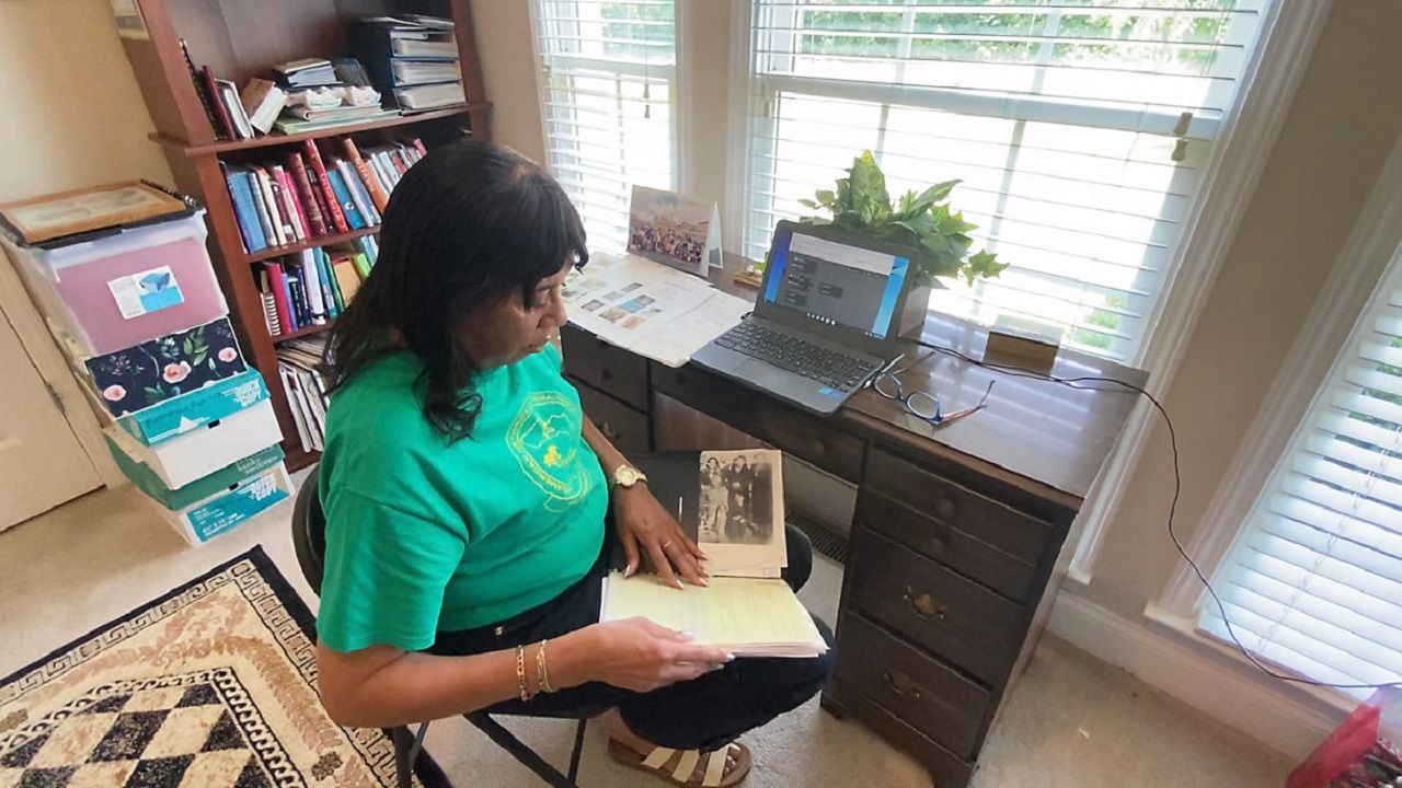 Laurann Pierce looks over family tree notes. (Spectrum News 1/Zyneria Byrd)