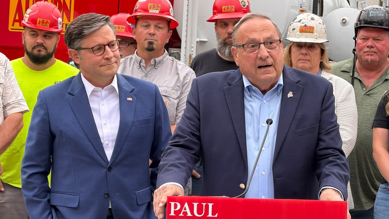Former Gov. Paul LePage speaks to reporters Monday in Auburn as House Speaker Mike Johnson looks on. (Spectrum News/Susan Cover)