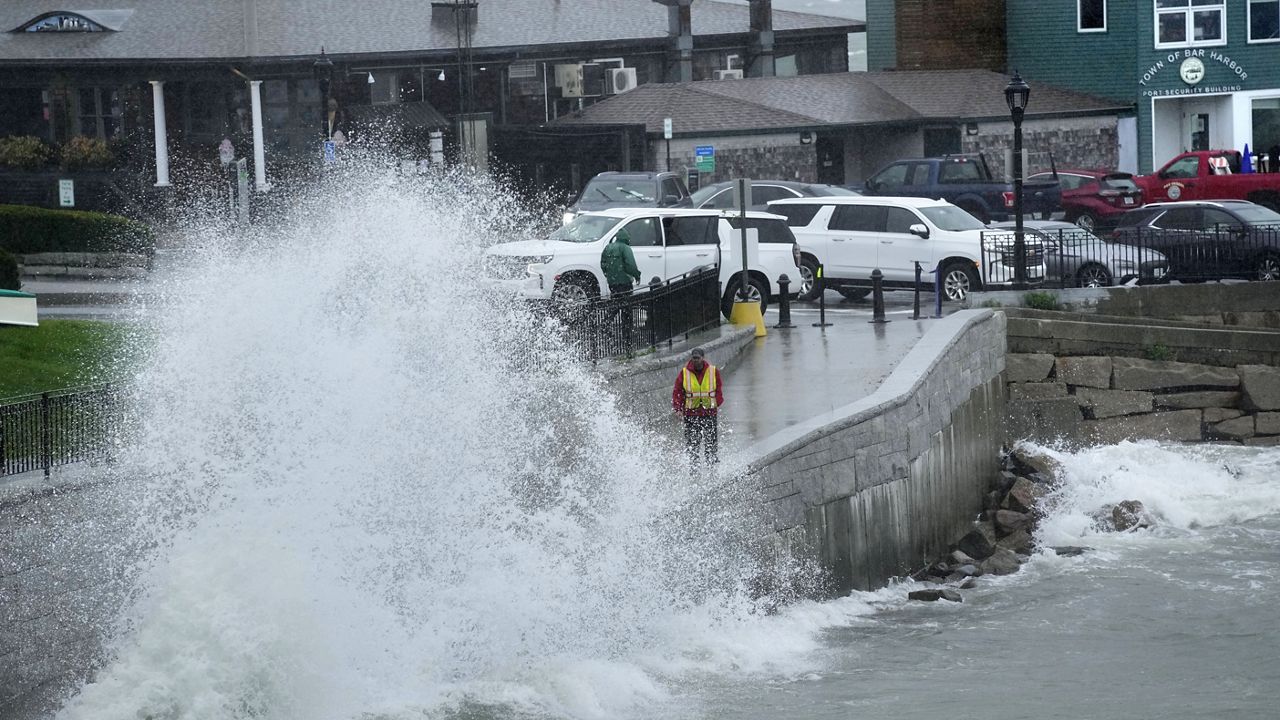 A city worker views a wave crashing along a walkway during storm Lee, Saturday, Sept. 16, 2023, in Bar Harbor, Maine. (AP Photo/Robert F. Bukaty)