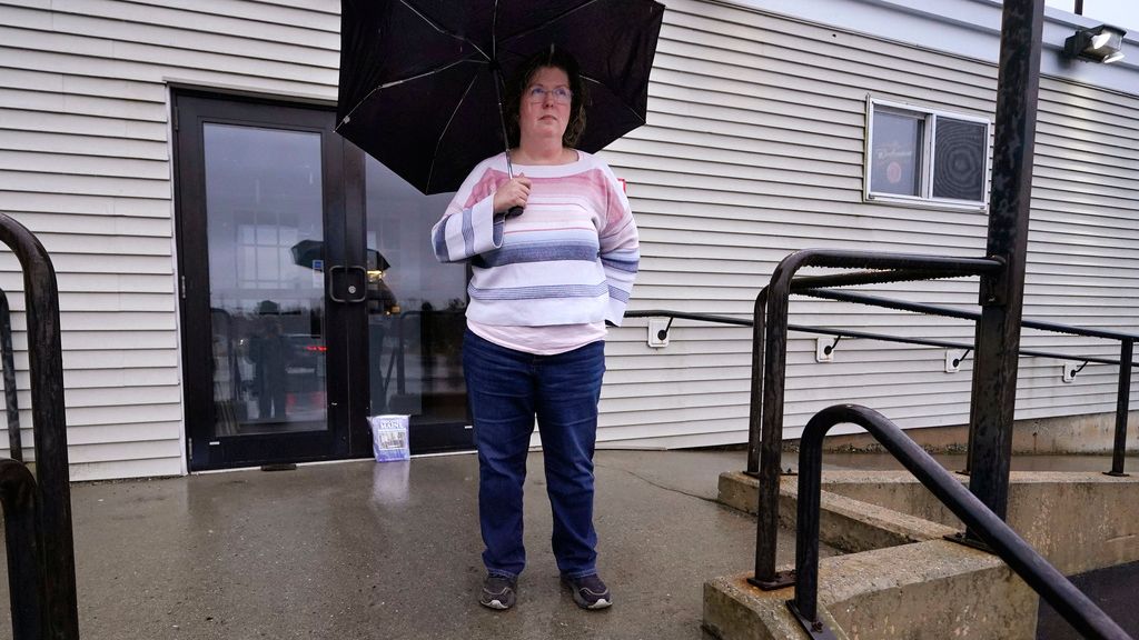 Kathy Lebel, the owner of Schemengees Bar & Grille, which is currently closed due to the mass shootings, stands for a portrait on Wednesday, Dec. 27, 2023, in Lewiston, Maine. Immediately after Maine's deadliest mass shooting, the owners of the bowling alley and the bar in Lewiston where the gunman killed a total of 18 people were certain their doors were closed for good. But as time passed following the Oct. 25 shooting, they came to the same conclusion: They had to reopen. (AP Photo/Charles Krupa)