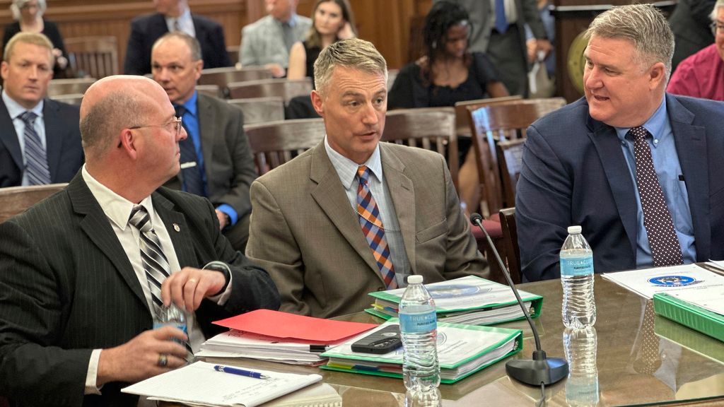 Col. Bill Ross, Maine state police chief, far right,prepares to address an independent commission investigating a mass shooting along with Lt. Col. Brian Scott, left, and Lt. Lucas Hare, middle, on Friday, May 24, in Lewiston. A bulletin about the deadliest mass shooting in Maine history that was sent to police agencies had been leaked on social media early on, complicating an already difficult search for the shooter, the state's top law enforcement official said Friday. (AP Photo/David Sharp)