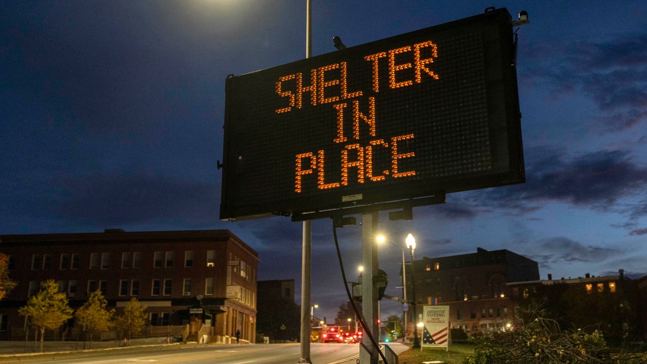 A sign advises residents to stay home, Thursday, Oct. 26, 2023, following a mass shooting at a restaurant and a bowling alley in Lewiston, Maine. Police continue to search for the suspect. (AP Photo/Robert F. Bukaty)
