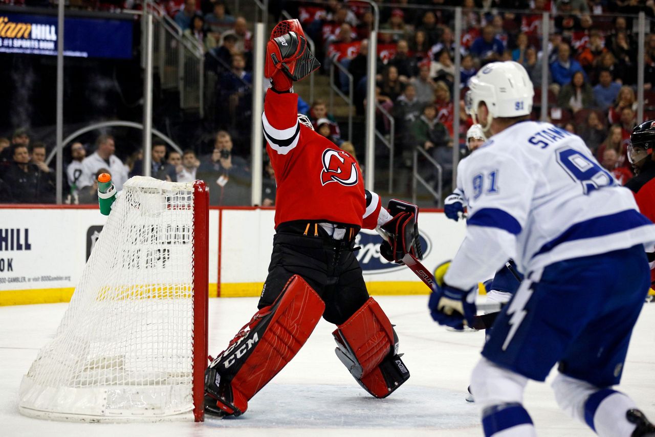 New Jersey Devils forward Kyle Palmieri (21) checks Tampa Bay