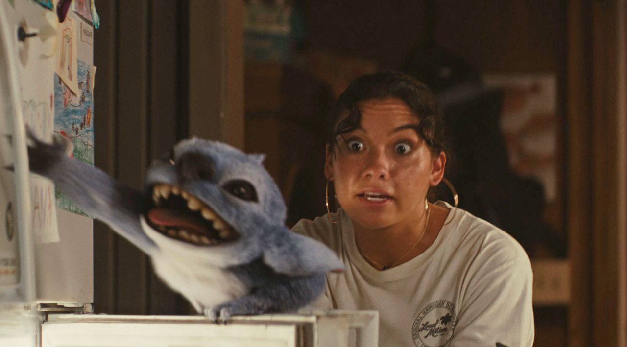 This image released by Disney shows the character Stitch, left, and Sydney Agudong, as Nani, in a scene from 