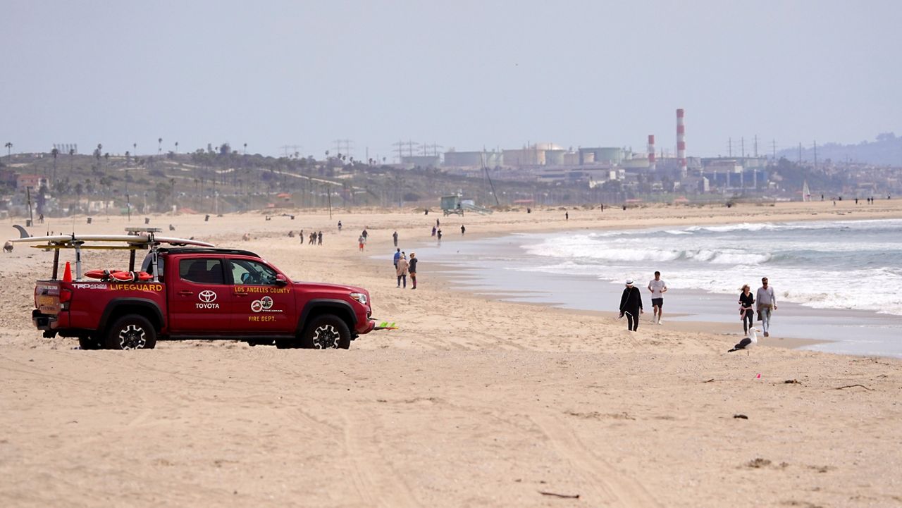 A Los Angeles County lifeguard patrols a sparsely populated Venice Beach, Saturday, March 28, 2020, in Los Angeles. (AP Photo/Mark J. Terrill)