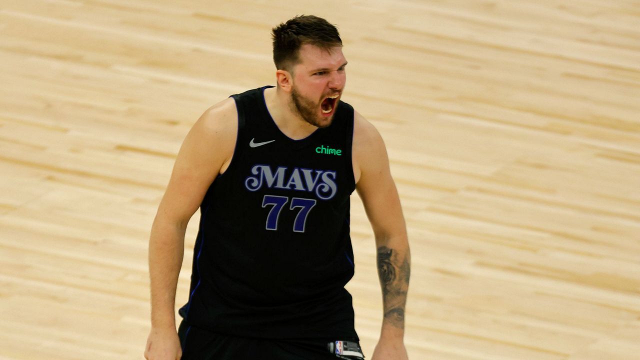 Dallas Mavericks guard Luka Doncic (77) celebrates after making a 3-point shot to take the lead against the Minnesota Timberwolves with seconds left during the second half of Game 2 of the NBA basketball Western Conference finals, Friday, May 24, 2024, in Minneapolis. (AP Photo/Bruce Kluckhohn)