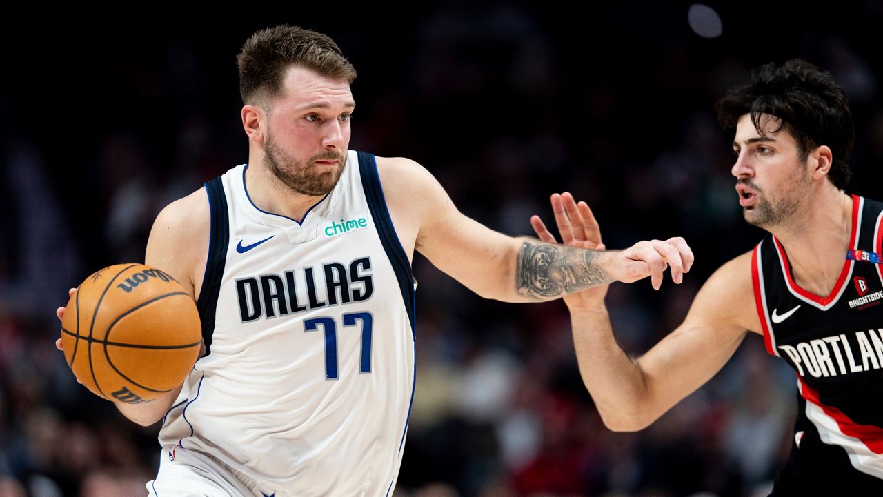 Dallas Mavericks guard Luka Doncic, left, dribbles the ball against Portland Trail Blazers forward Deni Avdija, right, during the first half of an NBA basketball game Sunday, Dec. 1, 2024, in Portland, Ore. (AP Photo/Howard Lao)