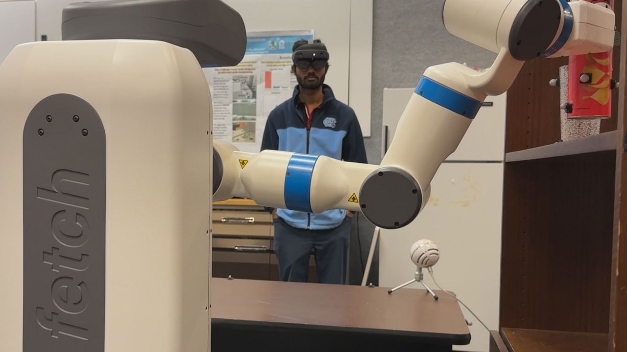 Researcher Maitrey Gramopadhye tests a voice-activated robot, which is being trained to perform simple tasks like moving objects on command. (Spectrum News 1/Rob Wu)