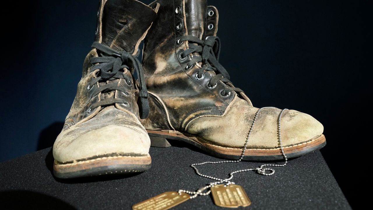 Combat boots and dog tags worn by Alan Alda as he portrayed the wisecracking surgeon Hawkeye on the beloved television series "M-A-S-H" are displayed at Heritage Auctions in Irving, Texas, Wednesday, July 5, 2023. The items are up auction on July 28. (AP Photo/LM Otero)