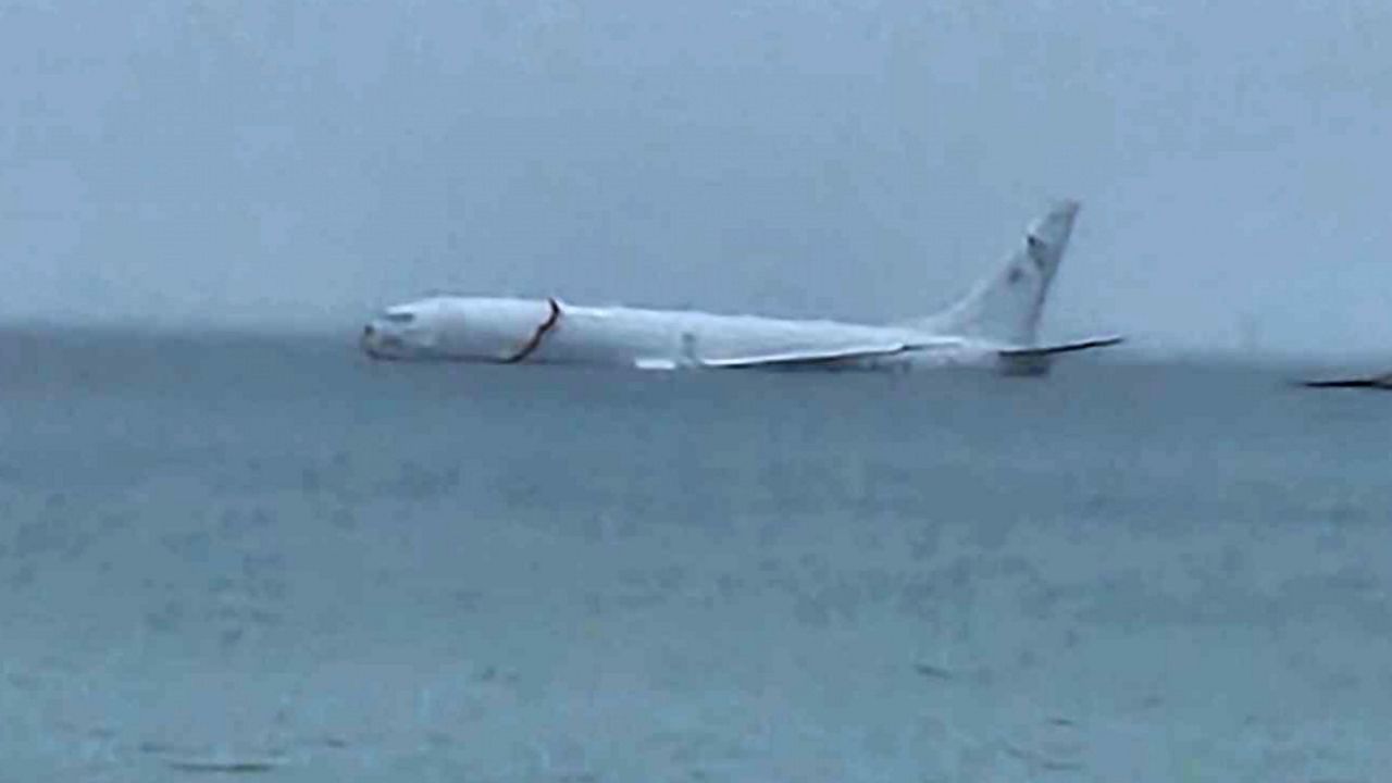 This photo provided by Diane Dircks shows a U.S. Navy plane that overshot a Marine base on Kaneohe Bay, Hawaii, Monday, Nov. 20, 2023. An official says all nine people aboard the plane have escaped injury. (Diane Dircks via AP)