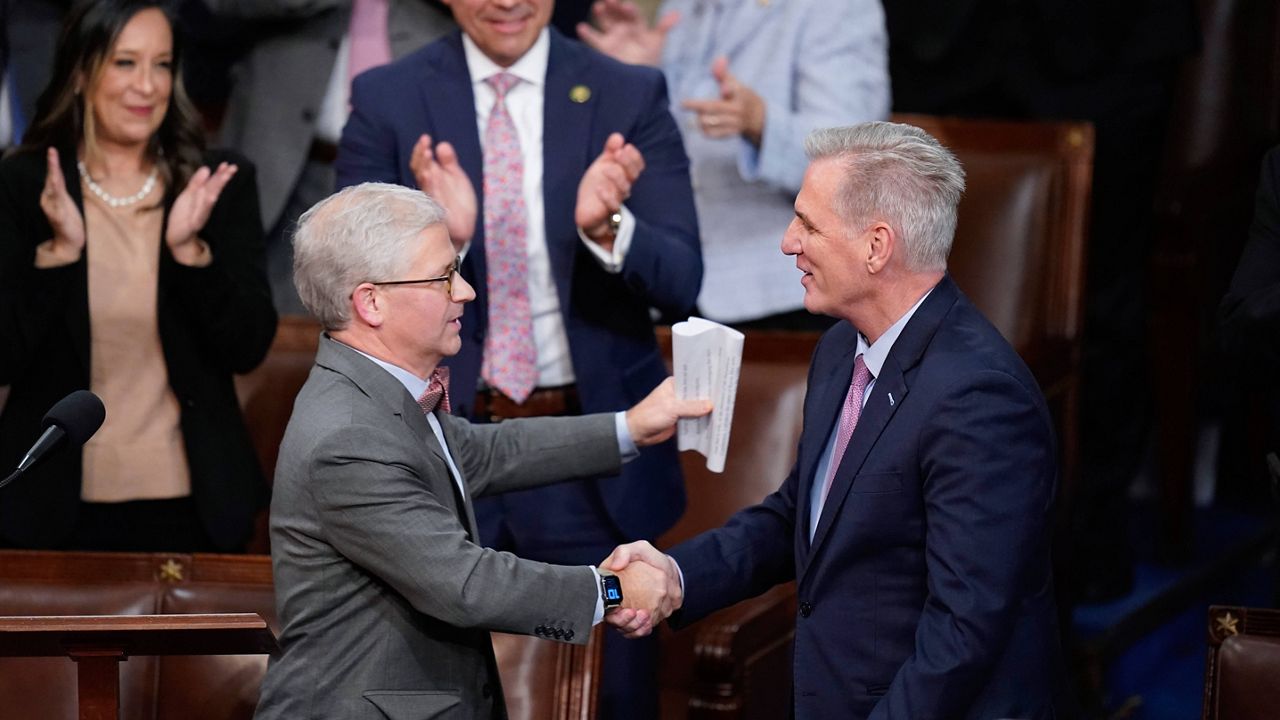 Rep. Patrick McHenry, R-N.C., left, shakes hands with Rep. Kevin McCarthy, R-Calif., after nominating him for a 14th vote in the House chamber as the House meets for the fourth day to elect a speaker and convene the 118th Congress in Washington, Friday, Jan. 6, 2023. (AP Photo/Alex Brandon)