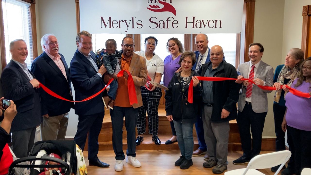 Dr. Tasia Cerezo of Meryl's Safe Haven cuts the ribbon on a new home for young adults transitioning out of foster care in Worcester on Thursday. (Spectrum News 1/Devin Bates)