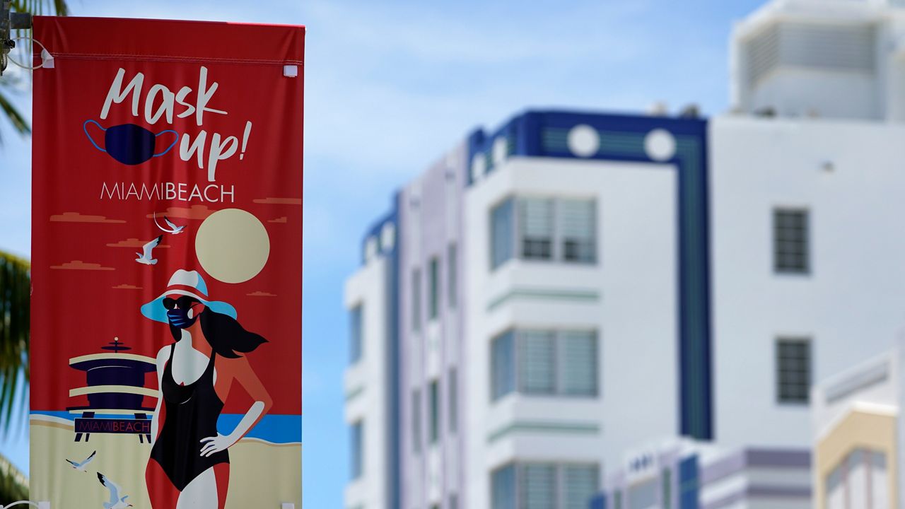 A sign urging people to wear masks to prevent the spread of the new coronavirus is posted, Tuesday, Aug. 11, 2020, near Art Deco hotels along Miami Beach, Florida's famed Ocean Drive in South Beach. (Wilfredo Lee/AP)