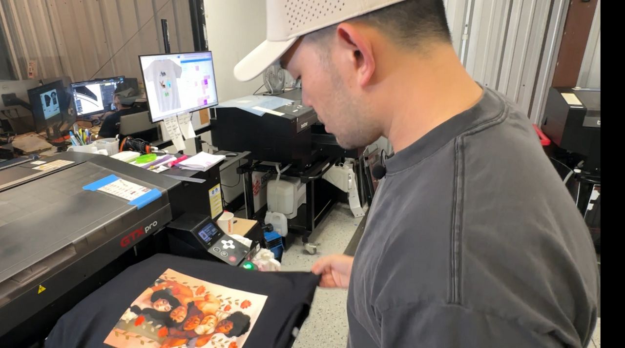 Mike Cho, owner and operator of Impress Ink in Orlando, says tariffs have created challenges for his screen-printing business. (Spectrum News/Jeff Allen)