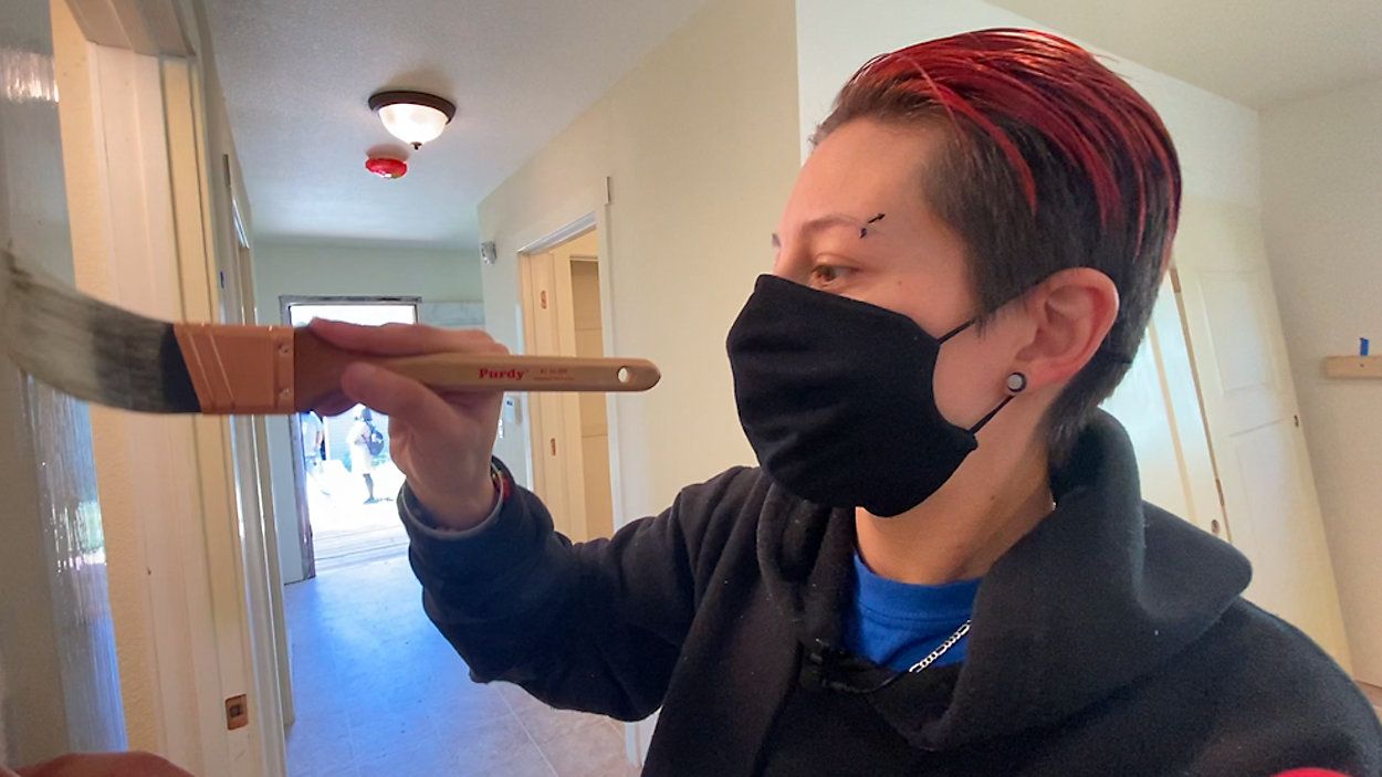Sabrina Suarez is  hard at work painting trim around the house.