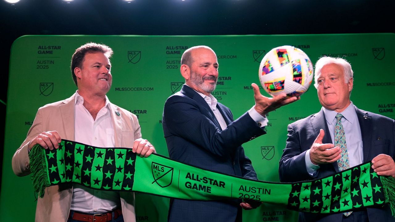 Major League Soccer Commissioner Don Garber, center, catches a soccer ball as he stands with Majority Owner and Chief Executive Officer of Austin FC Anthony Precourt, left, and Austin Mayor Kirk Watson, right, after announcing that Austin FC will host the 2025 MLS All-Star soccer game, Wednesday, May 15, 2024, in Austin, Texas. (AP Photo/Eric Gay)