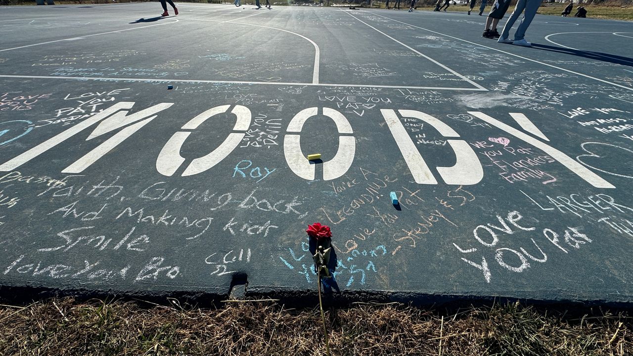 A rose sits near messages written on Patrick Moody Basketball Court. The town dedicated the court in his name two weeks before Moody passed away. (Spectrum News/Matthew Jaroncyk)