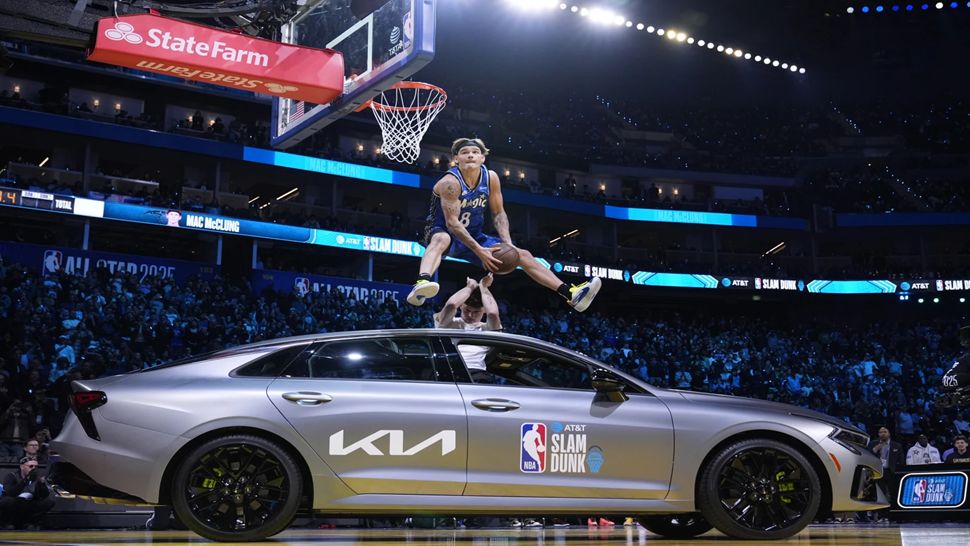 Orlando Magic guard Mac McClung dunks over a car during the slam dunk contest at the NBA basketball All-Star Saturday night festivities.