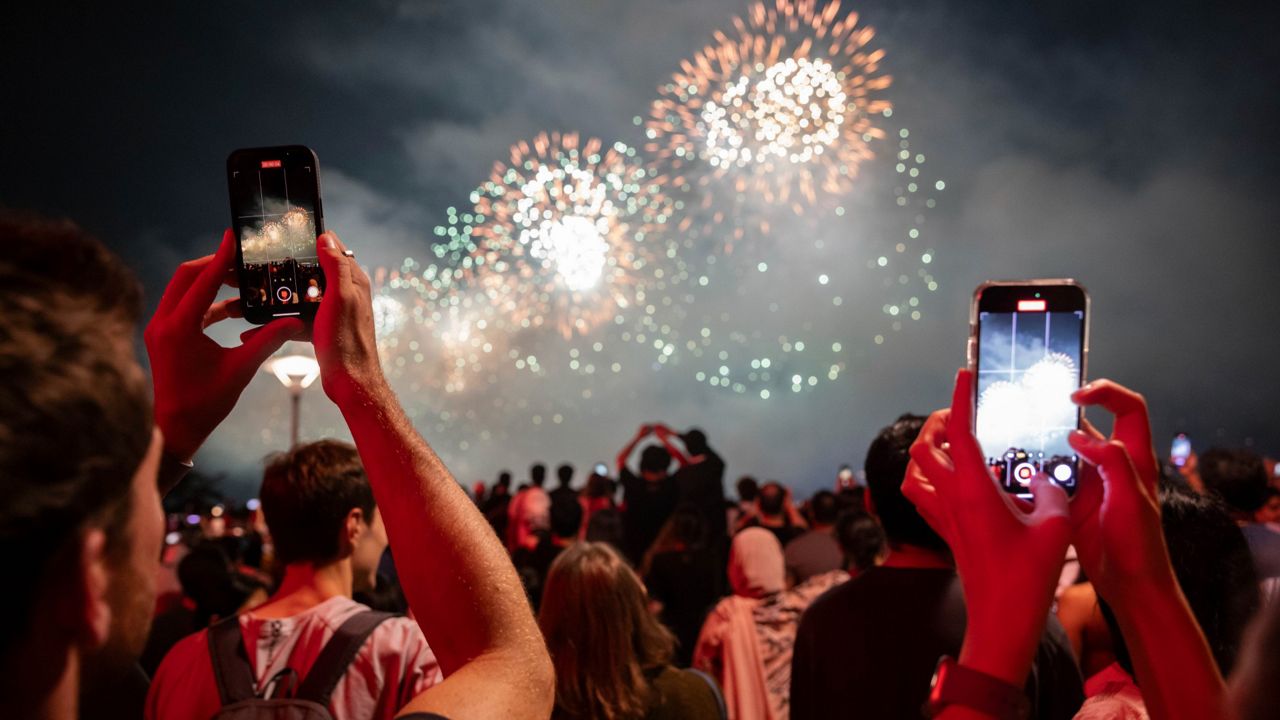 People watch the Macy's Fourth of July fireworks in New York, Tuesday, July 4, 2023. (AP Photo/Yuki Iwamura)