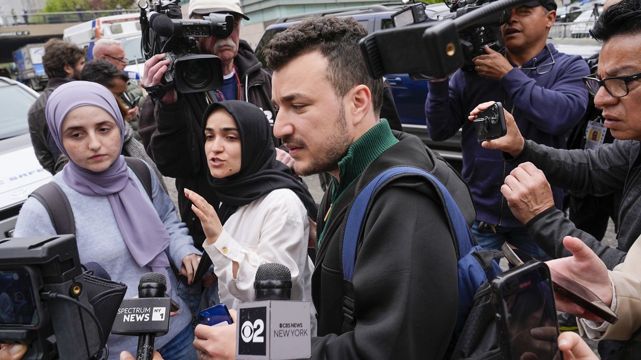 Members of the Columbia University Apartheid Divest group, including Sueda Polat, second from left, and Mahmoud Khalil, center, are surrounded by members of the media outside the Columbia University campus on Tuesday, April 30, 2024 in New York. (AP Photo/Mary Altaffer, File)