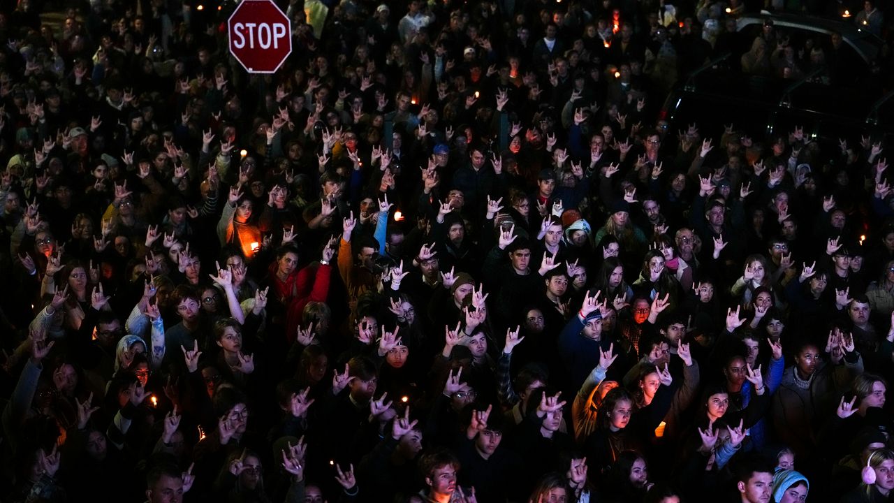 People sign "I love you" while gathered at a vigil for the victims of Wednesday's mass shootings, Oct. 29, 2023, outside the Basilica of Saints Peter and Paul in Lewiston, Maine. (AP Photo/Matt Rourke, file)