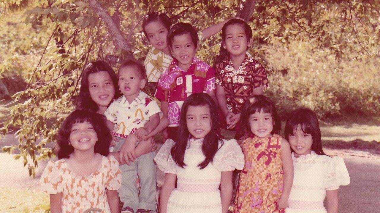 Mary Therese Hattori's siblings gathered at her family’s manzanita tree on Guam.  Front row, left to right: Yvonne, Mary Therese, Barbara, Margaret. Second row, left to right: Anne, Robert, Paul, Stephen, Paul and Thomas. (Photo courtesy of Mary Therese Hattori)