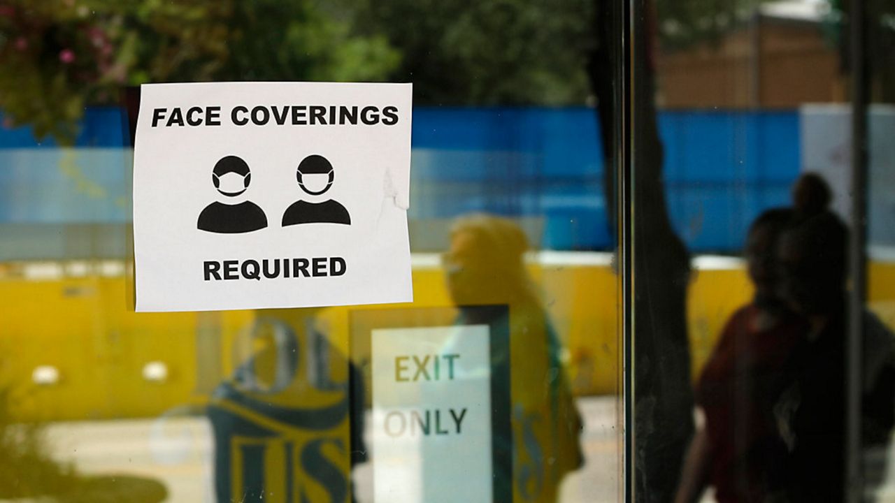 Face coverings required sign. (Spectrum File)