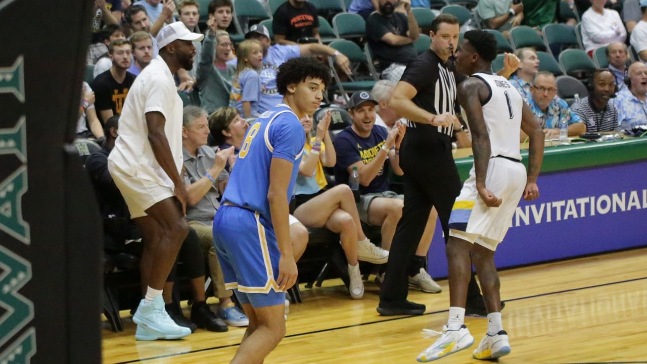 Naismith Memorial Basketball Hall of Fame inductee Dwyane Wade, left, offered support to Marquette guard Kam Jones (1) from courtside at the Stan Sheriff Center on Day 1 of the Allstate Maui Invitational.