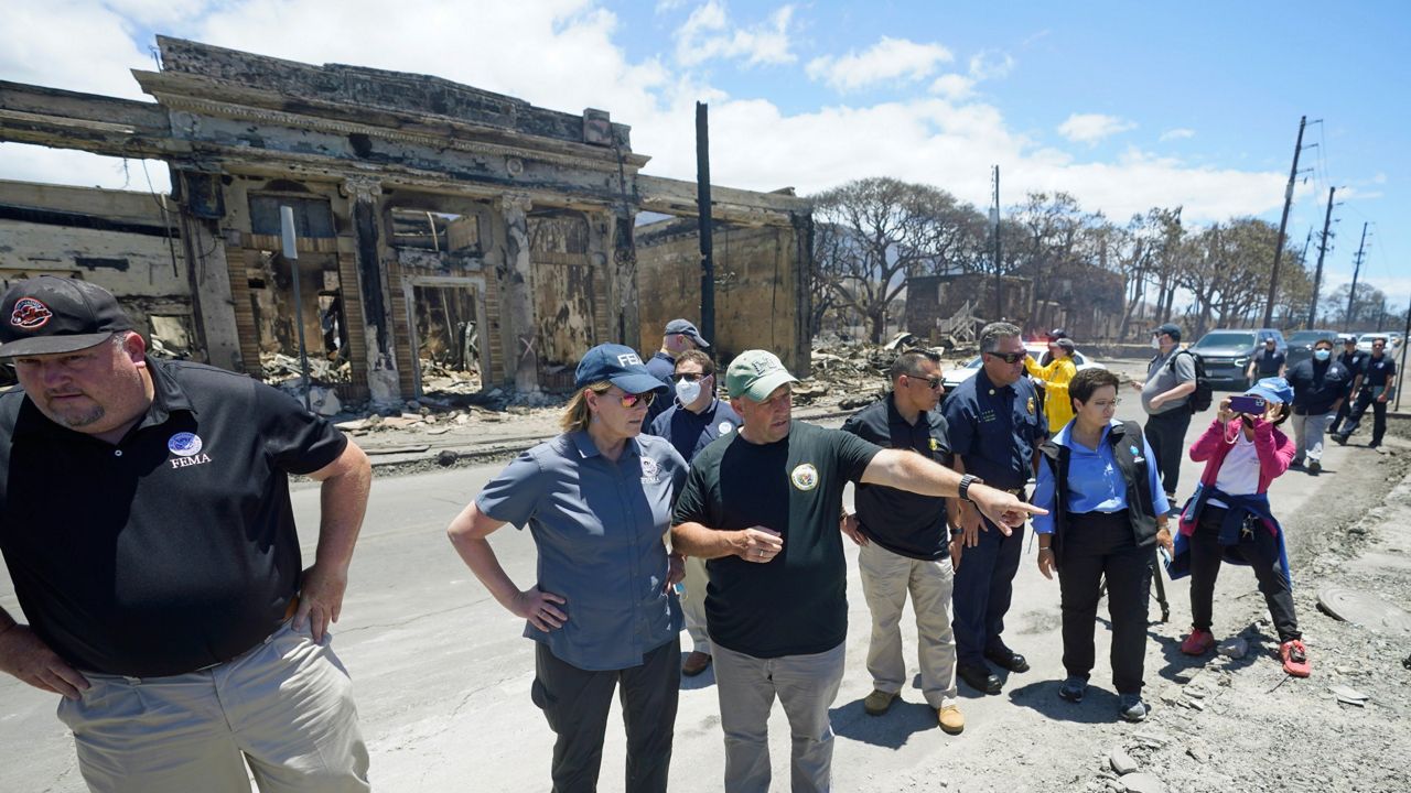 Hawaii Gov. Josh Green, center, points to damage as he speaks with Federal Emergency Management Agency Administrator Deanne Criswell during a tour of wildfire damage, Saturday, Aug. 12, 2023, in Lahaina, Hawaii. On Friday, Aug. 18, FEMA said it approved $2.3 million in assistance to roughly 1,300 households in Maui so far, as the federal government tries to help survivors of the devastating wildfires. (AP Photo/Rick Bowmer, File)