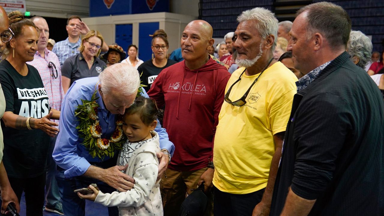 President Joe Biden hugs a child as he meets with community members impacted by the Maui wildfires at Lahaina Civic Center, Monday, Aug. 21, 2023, in Lahaina, Hawaii. (AP Photo/Evan Vucci)