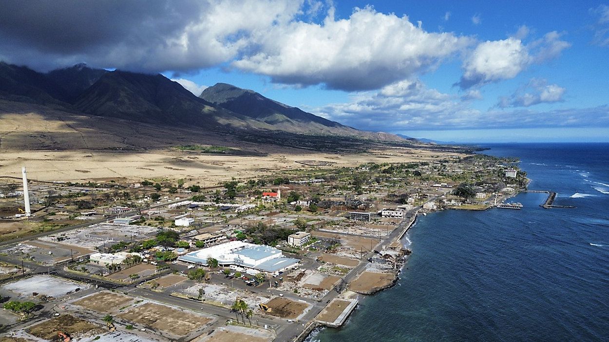 A general view of Front Street shows the primary debris from last year's wildfire being removed from commercial properties, Wednesday, June 26, 2024, in Lahaina, Hawaii. (AP Photo/Mengshin Lin)