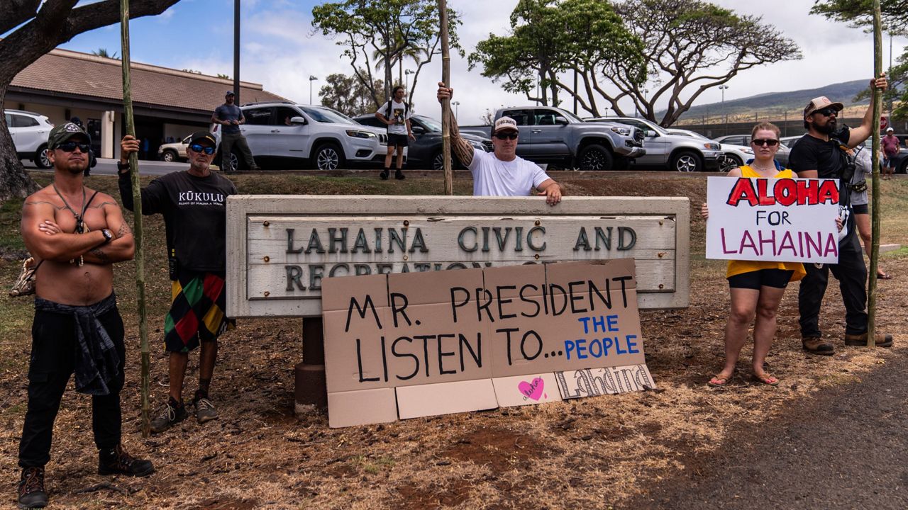 People wait for the arrival of President Joe Biden outside the Lahaina Civic Center in Lahaina, Hawaii, Monday, Aug. 21, 2023. (AP Photo/Jae C. Hong)