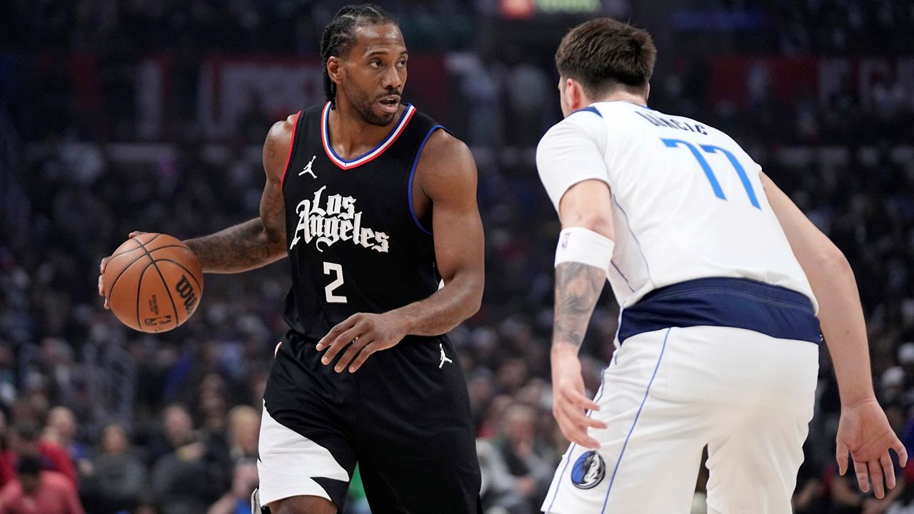 Los Angeles Clippers forward Kawhi Leonard, left, looks to pass while under pressure from Dallas Mavericks guard Luka Doncic during the first half in Game 2 of an NBA basketball first-round playoff series Tuesday, April 23, 2024, in Los Angeles. (AP Photo/Mark J. Terrill)