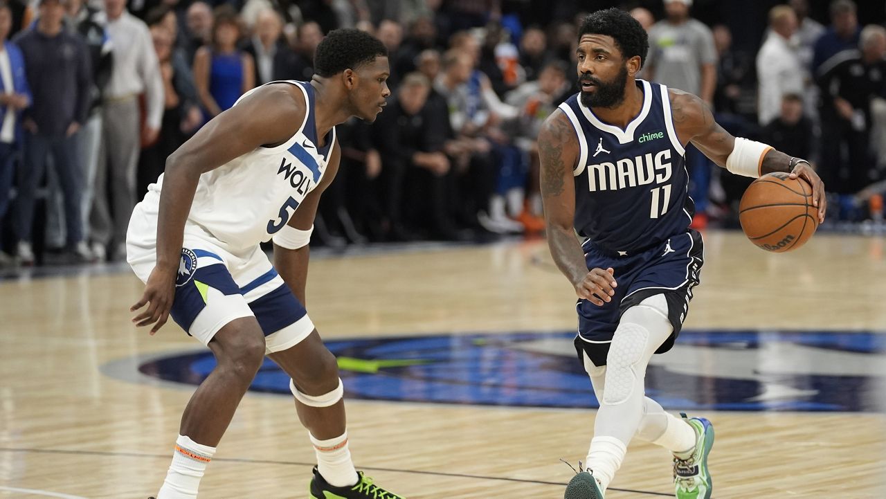 Dallas Mavericks guard Kyrie Irving (11) works toward the basket as Minnesota Timberwolves guard Anthony Edwards (5) defends during the first half of an NBA basketball game, Tuesday, Oct. 29, 2024, in Minneapolis. (AP Photo/Abbie Parr)