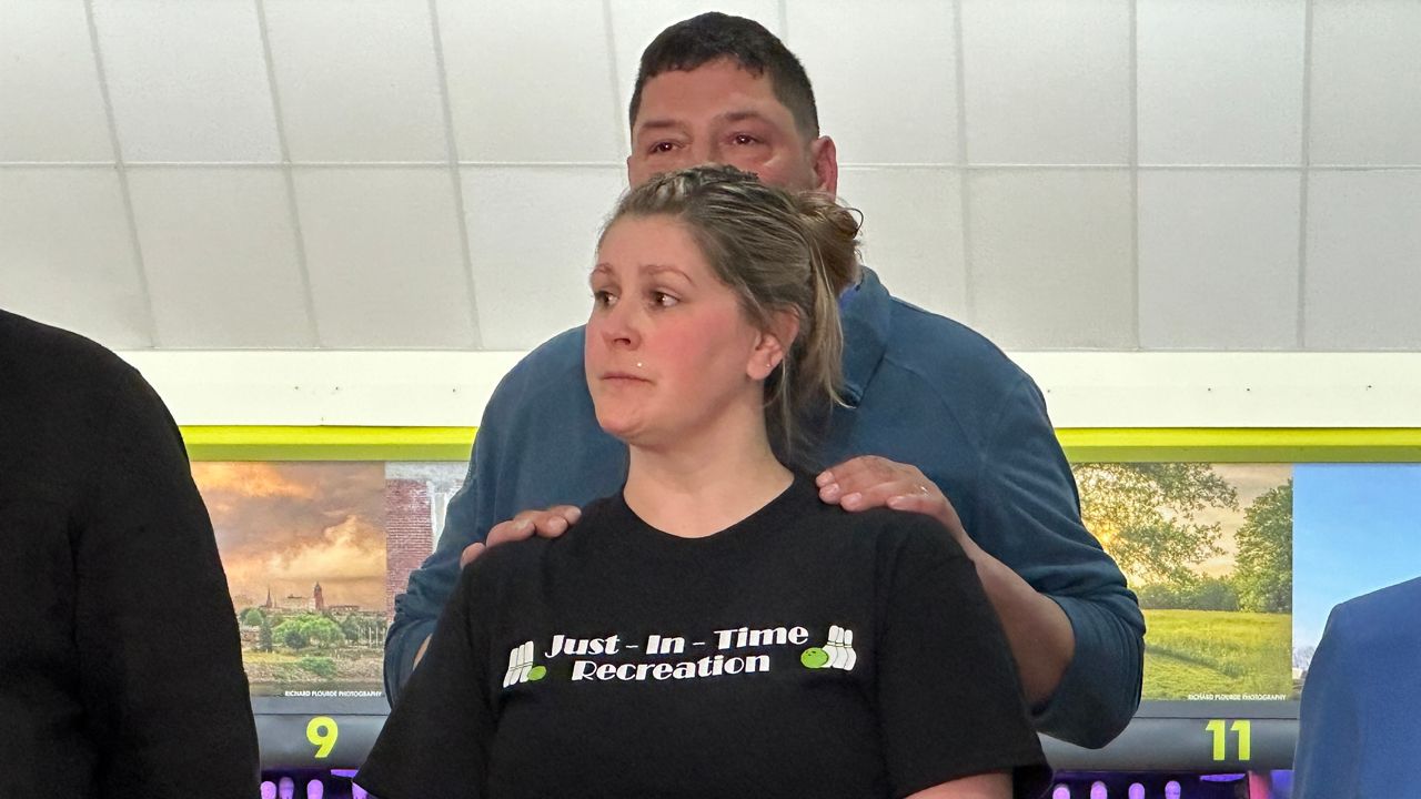 Justin and Samantha Juray listen during a May ceremony to mark the reopening of the bowling alley after the Oct. 25 mass shooting. (Spectrum News file photo)