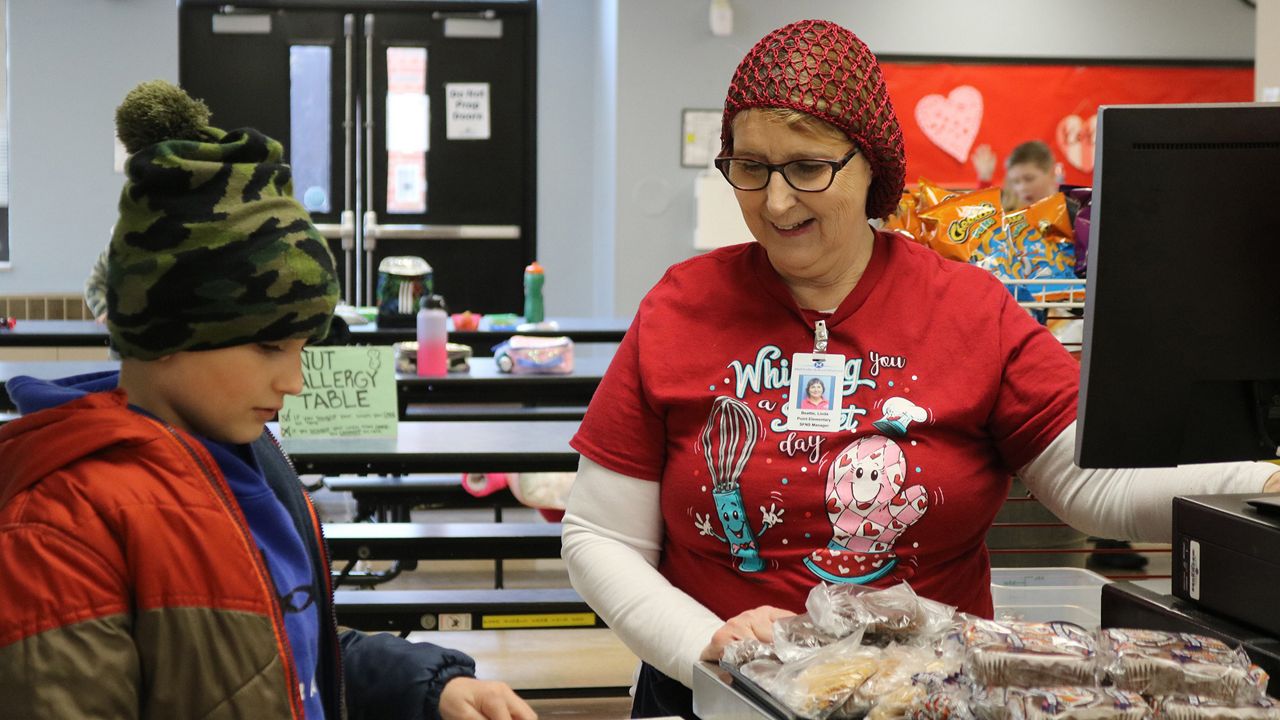 A Mehlville School District food technician helps a student. The district is holding an interview event Thursday, June 15, to fill bus driver, custodian and food technician positions. (Photo Credit: Mehlville School District )