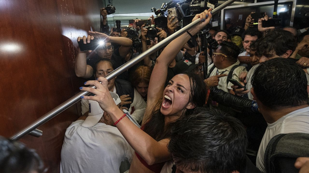 Protesters attempt to break into a room in the Senate as lawmakers weigh the government's proposed judicial reform, which would make judges stand for election, in Mexico City, Tuesday, Sept. 10, 2024. (AP Photo/Felix Marquez)