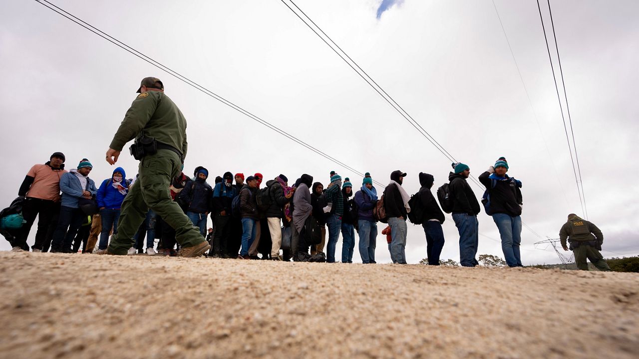 FILE - Men seeking asylum, including Peruvians, line up as they wait to be processed after crossing the border with Mexico nearby, on April 25, 2024, in Boulevard, Calif. (AP Photo/Gregory Bull, File)