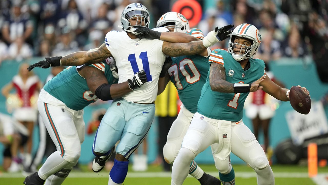 Miami quarterback Tua Tagovailoa stood back to pass as Dallas linebacker Micah Parsons was held back by offensive tackle Kendall Lamm (70) in Sunday's game in Miami Gardens, Fla. 