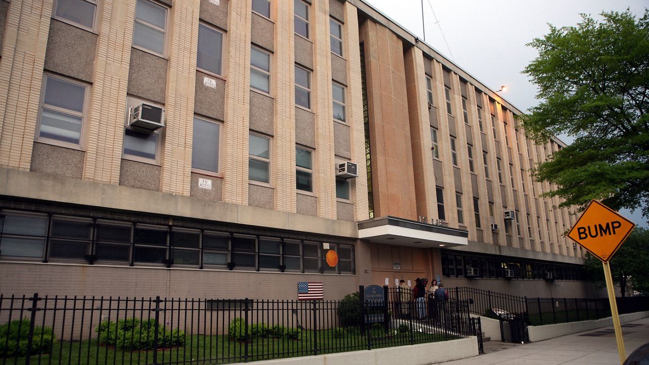 This May 14, 2009 file photo, shows a few people gathering on the steps of the Susan B. Anthony middle school in the Queens borough of New York. (AP Photo/David Karp, File)