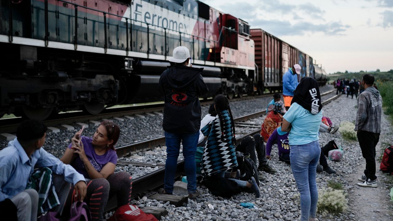 Migrants watch a train go past as they wait along the train tracks hoping to board a freight train heading north, in Huehuetoca, Mexico, Sept. 19, 2023. Ferromex, Mexico's largest railroad company announced that it was suspending operations of its cargo trains due to the massive number of migrants that are illegally hitching a ride on its trains moving north towards the U.S. border. (AP Photo/Eduardo Verdugo)