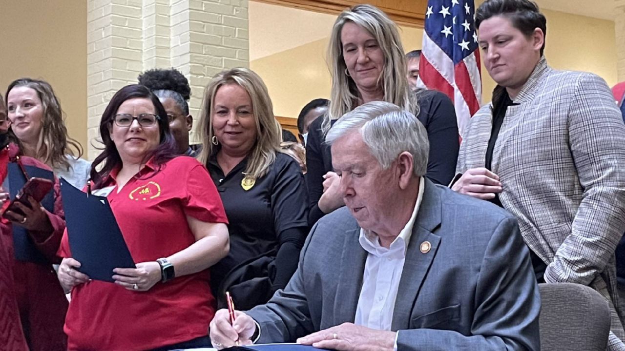 Missouri Gov. Mike Parson signs copies of a bill giving state employees an 8.7% pay raise Thursday March 2, 2023 in St. Louis. The measure went into effect earlier this week and will show up on employee paychecks. (Spectrum News/Gregg Palermo)