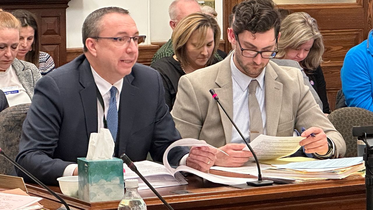 Maine Department of Public Safety Commissioner Mike Sauschuck, left, talks about the governor's violence prevention bill Thursday as committee analyst Eli Murphy listens. (Spectrum News/Susan Cover)