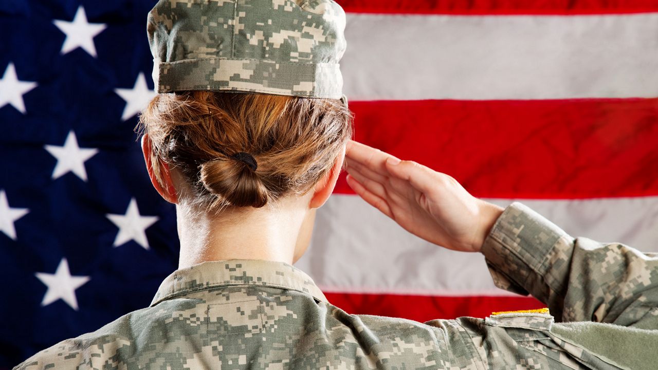 Female American soldier standing & saluting.