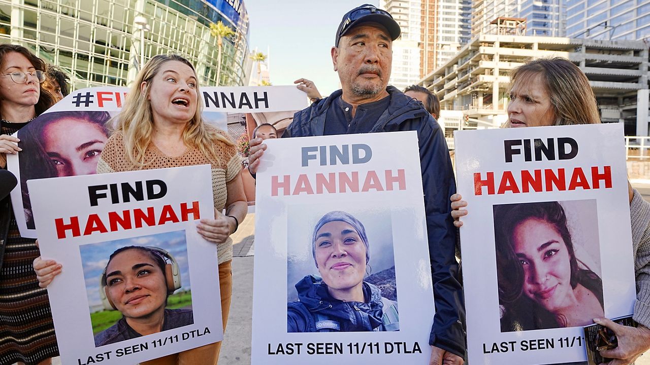 Ryan Kobayashi, center, holds a picture of his missing daughter Hannah Kobayashi outside Crypto.com Arena, Thursday, Nov. 21, 2024 in Los Angeles. Ryan Kobayashi, who had been in the search party, was found dead Sunday in a parking lot near LA International Airport by apparent suicide. (AP Photo/Damian Dovarganes)