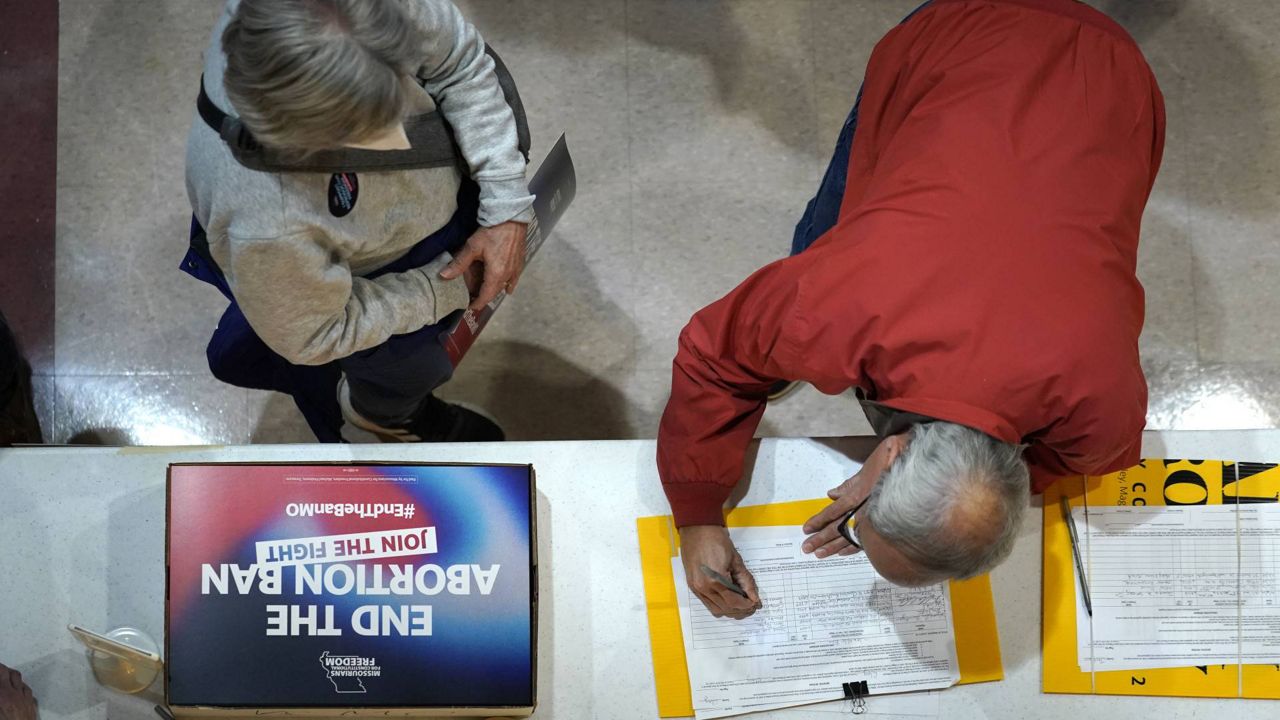 A resident places his signature on a petition during Missourians for Constitutionals Freedom kick-off petition drive, Feb. 6, 2024 in Kansas City, Mo.(AP Photo/Ed Zurga, File)