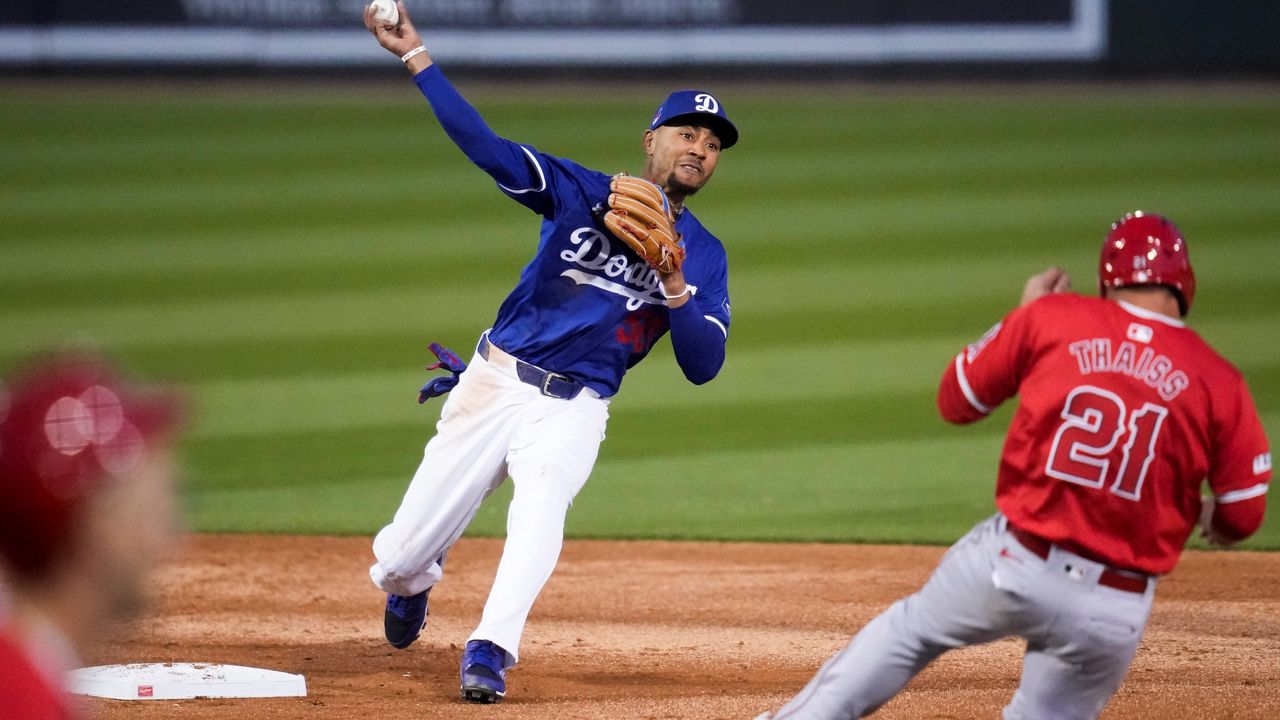 Los Angeles Dodgers second baseman Mookie Betts (50) throws to first as Los Angeles Angels' Zach Neto grounds in to a force out during the third inning of a spring training baseball game in Phoenix, Tuesday, March 5, 2024. (AP Photo/Ashley Landis)