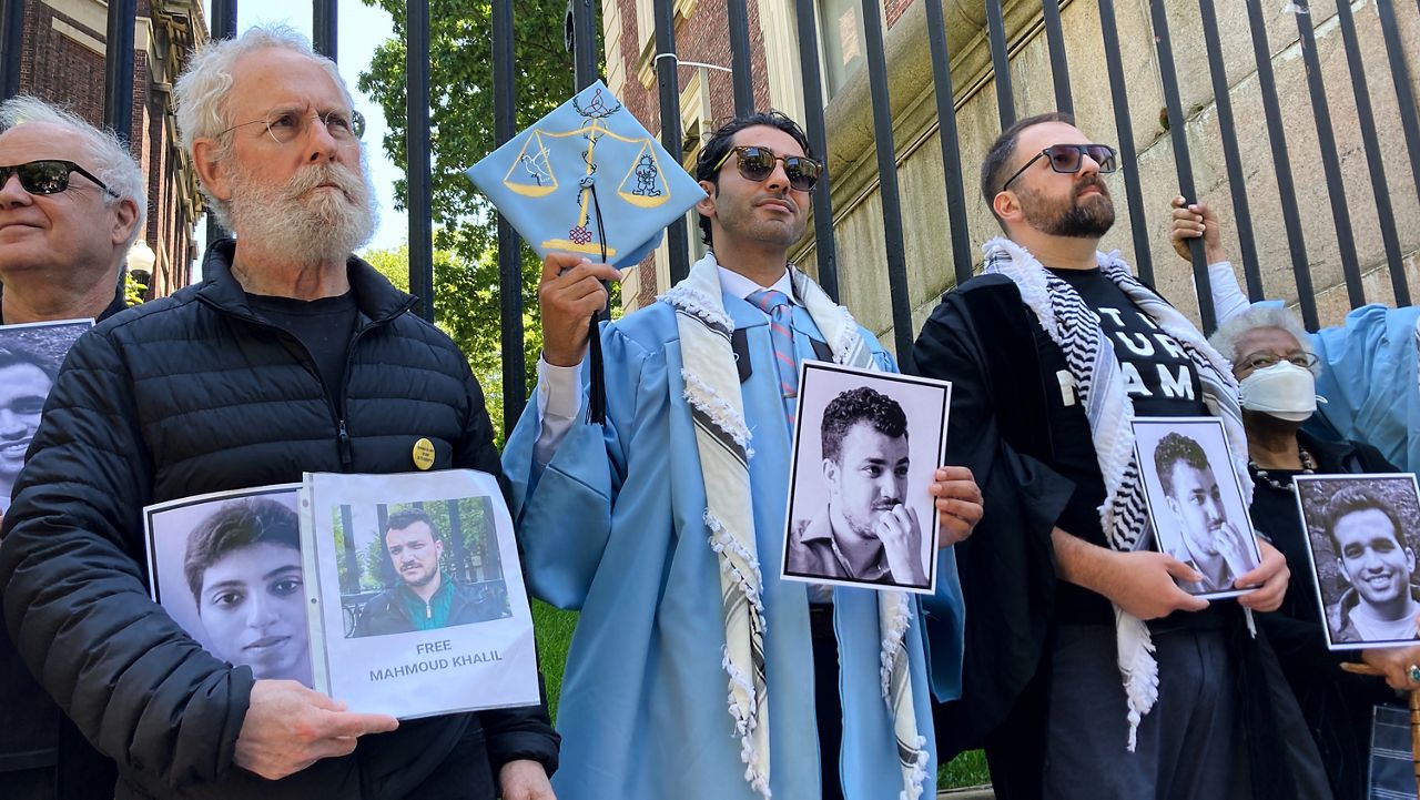 Mohsen Mahdawi, center, holds a photo of Mahmoud Khalil while posing for a photo with demonstrators outside the gates of Columbia University after graduating, Monday, May 19, 2025, in New York. (AP Photo/Jake Offenhartz)