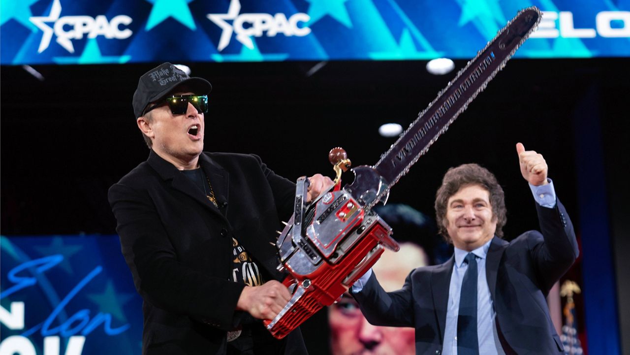 Elon Musk holds up a chainsaw he received from Argentina's President Javier Milei, right, as they arrive to speak at the Conservative Political Action Conference, CPAC, at the Gaylord National Resort & Convention Center, Feb. 20, 2025, in Oxon Hill, Md. (AP Photo/Jose Luis Magana, File)