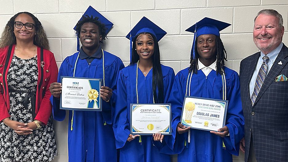 Abidmad Babin (left), Jordynn Mitchell (middle), and Douglass James III (right) accept awards at their Mercy Drive Kidz Zone graduation. (Spectrum News/Brandon Spencer)